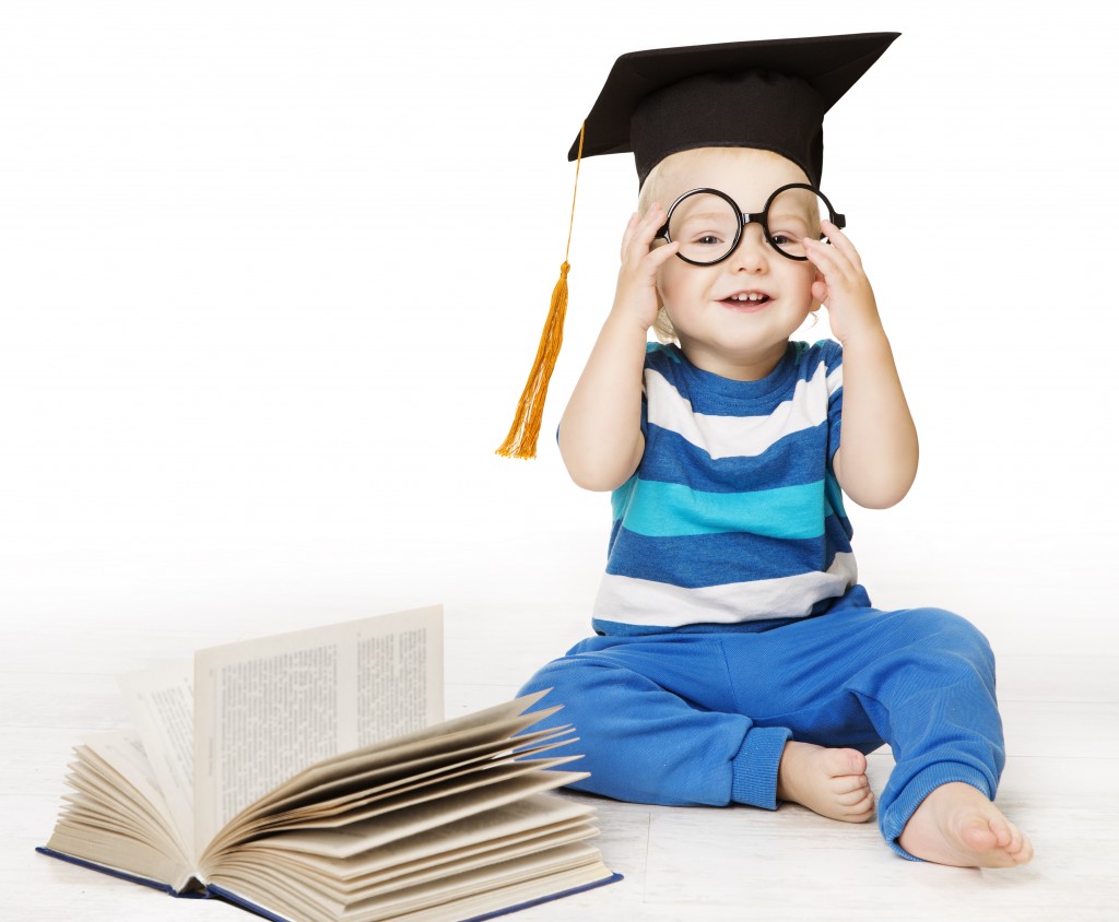 kid with toga cap and book