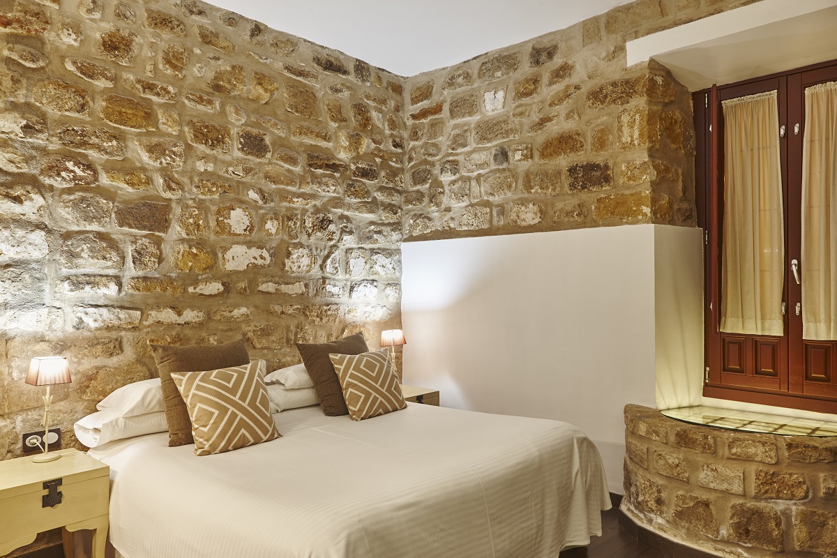 Bedroom with stone walls. Comfortable modern hotel room