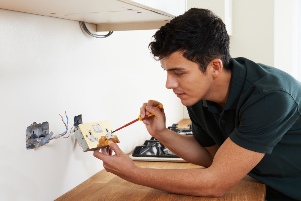 man repairing a switchboard