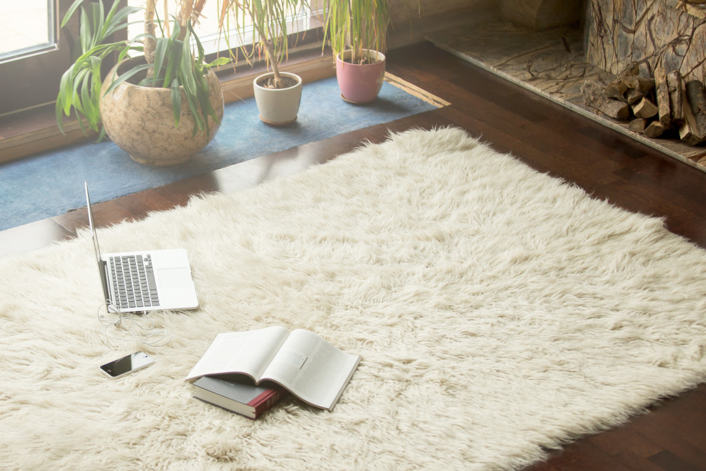 a comfy carpet with a computer and journal on top