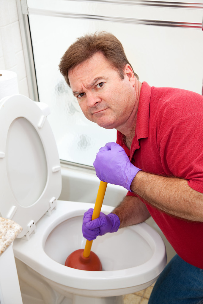 man cleaning a toilet