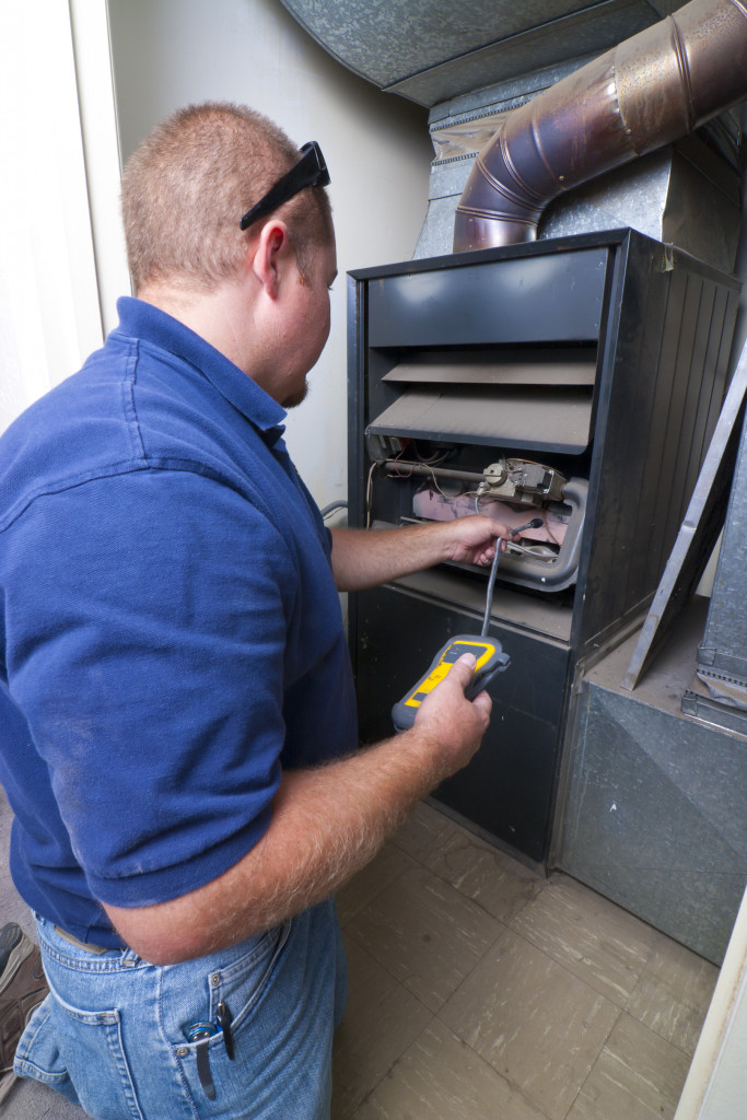 Technician fixing an indoor furnace.