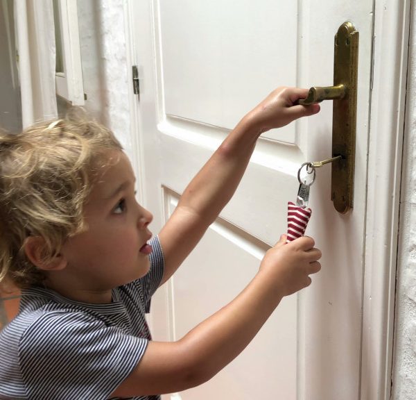 A young child trying to open a door with a key
