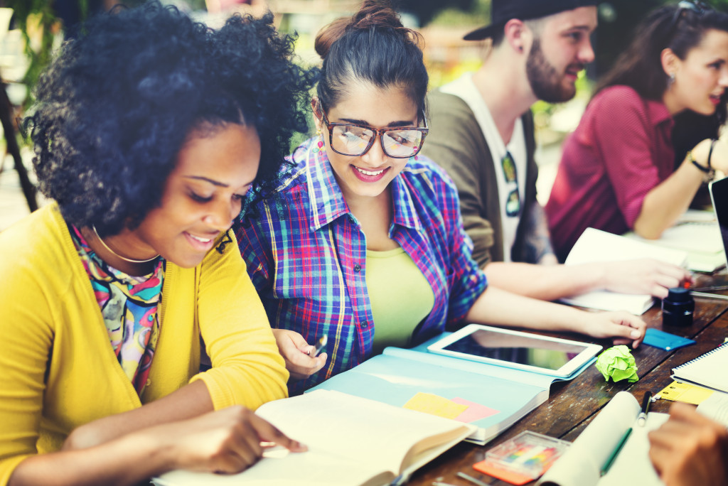 Two women reading books to upskill their career