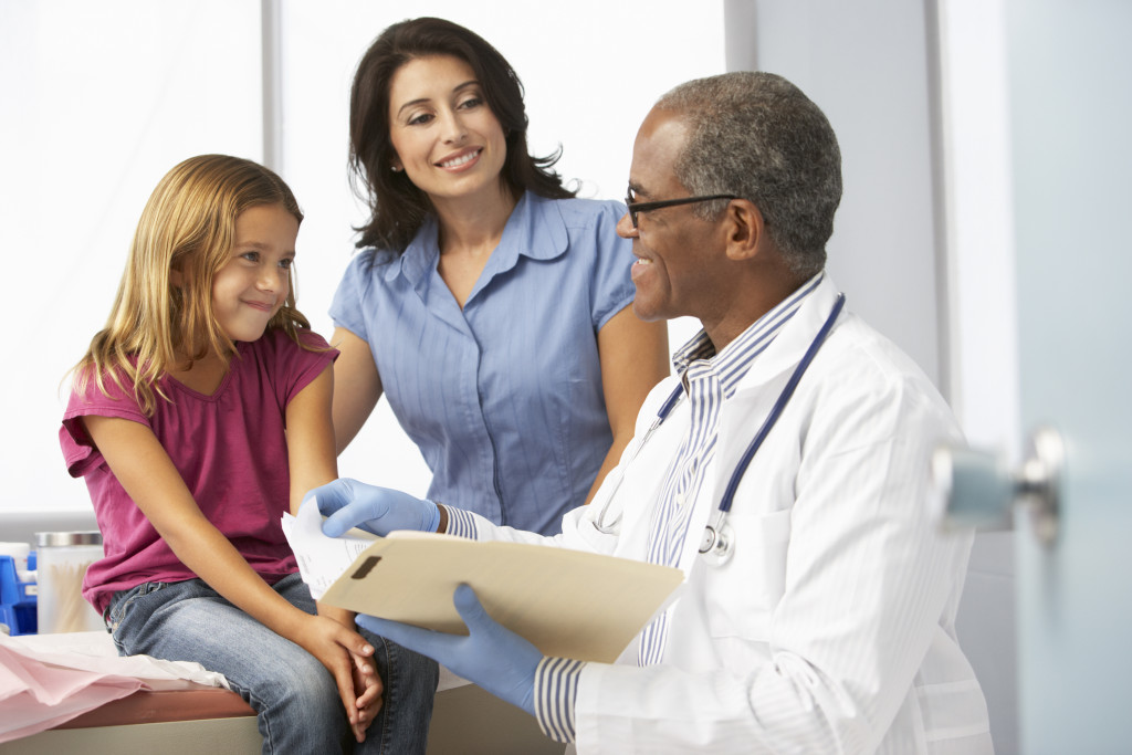 a young girl and her mother talking to a medical professional