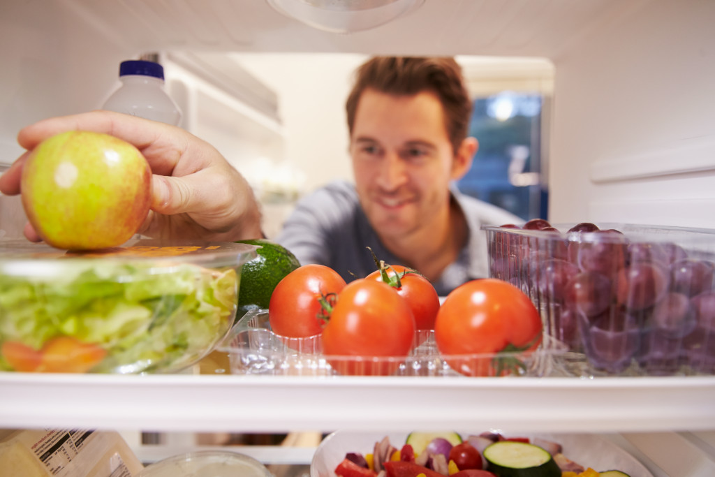 a man placing food on the refrigerator