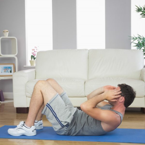 man doing crunches or sit ups at home