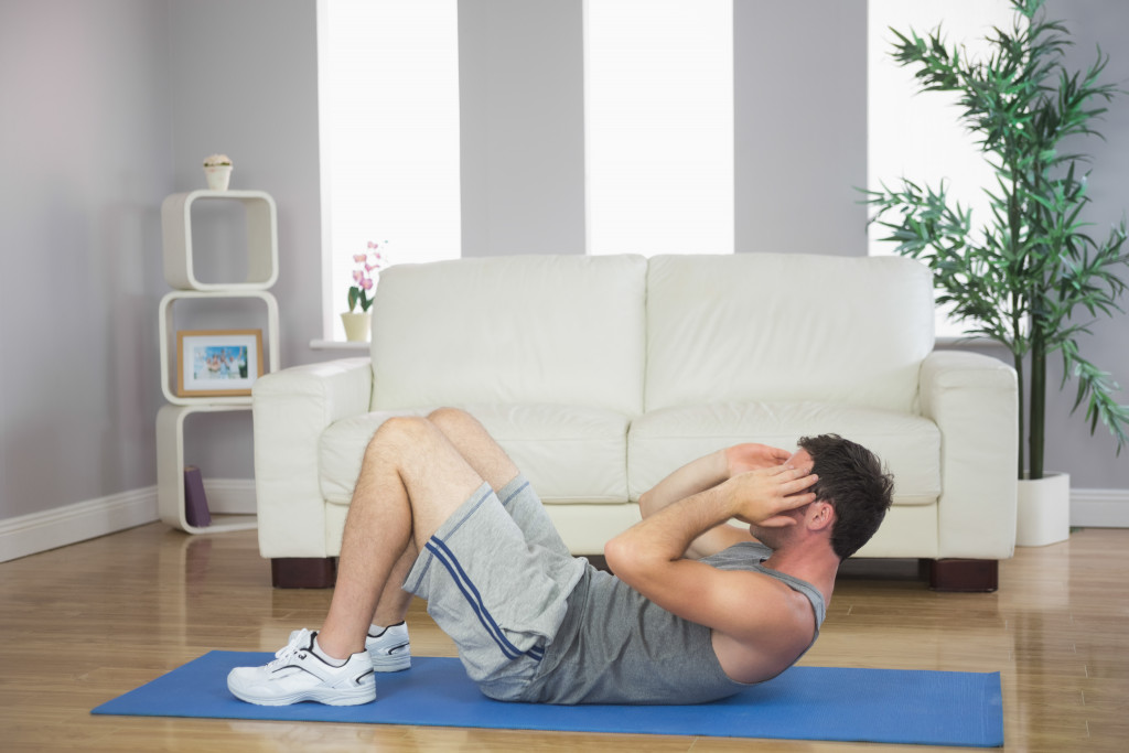 man doing crunches or sit ups at home