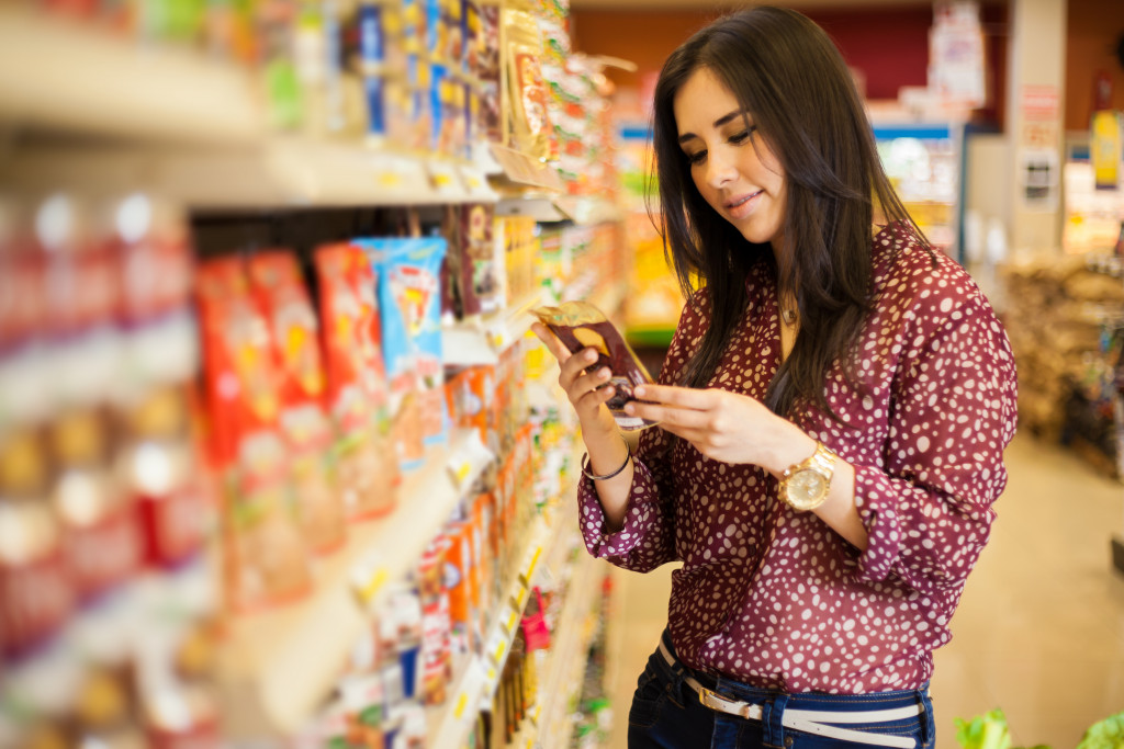 young woman examining label at a grocery store