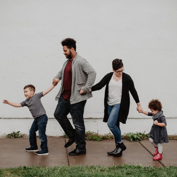 Family Of Four Walking At The Street