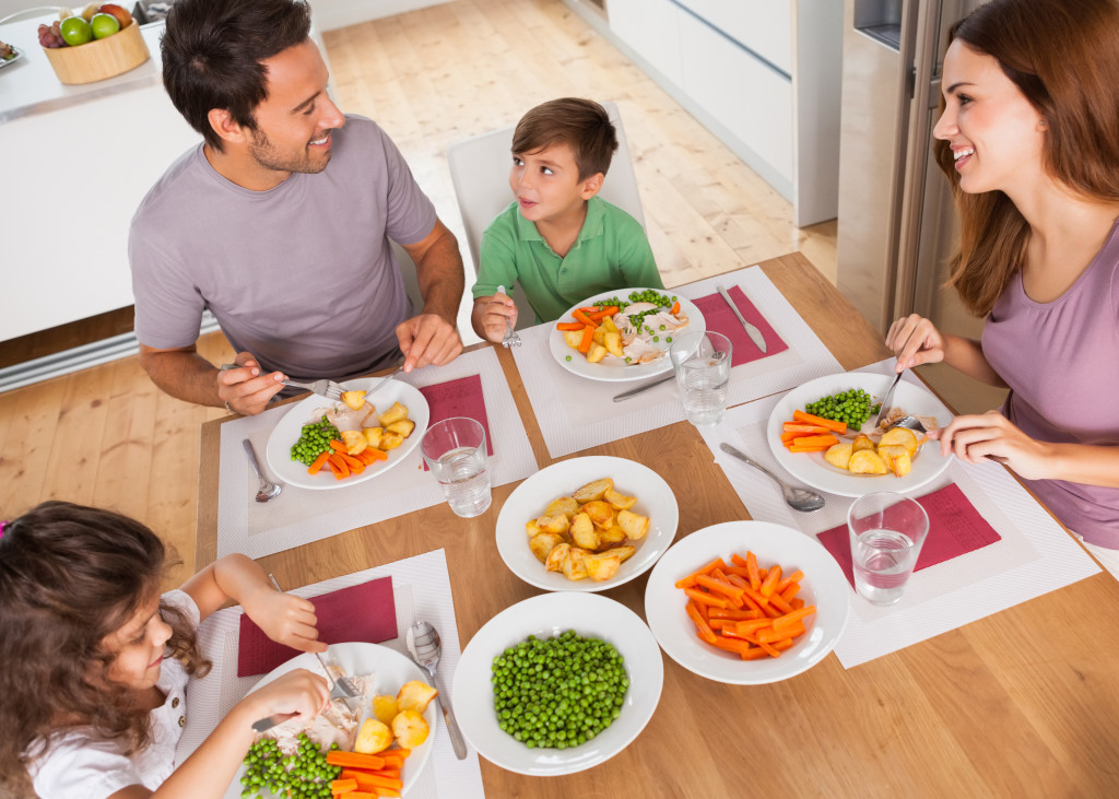 family smiling and talking while eating healthy food 