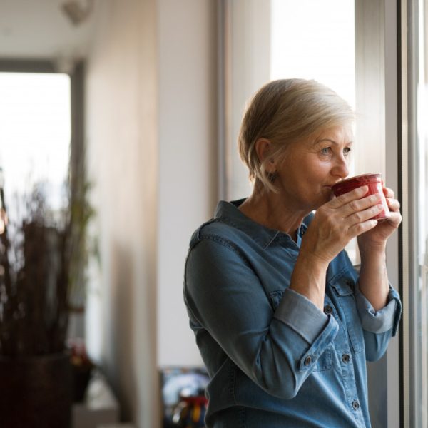 senior woman alone at home drinking coffee