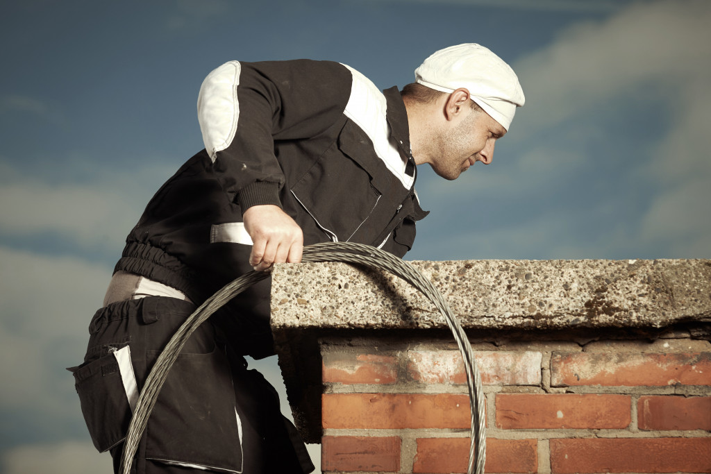 professional chimney cleaner on the roof