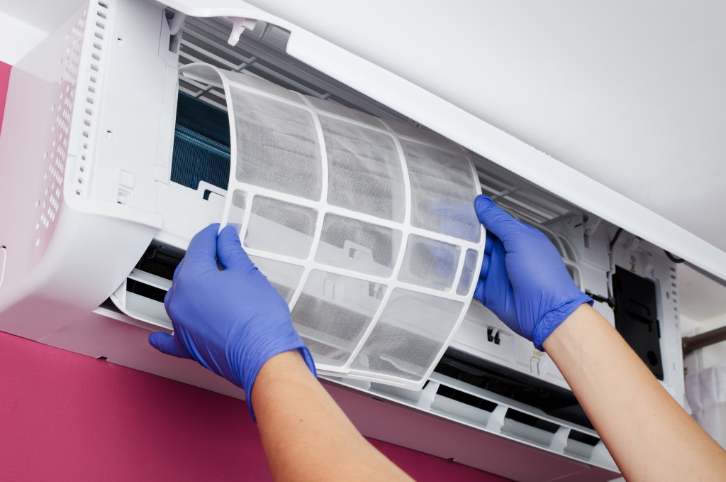 hands cleaning aircon filter