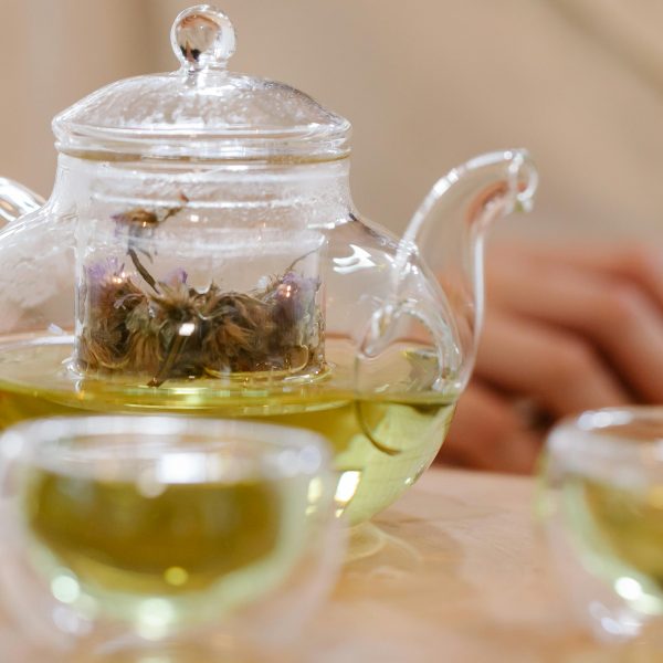 green tea in a glass teapot and teacups